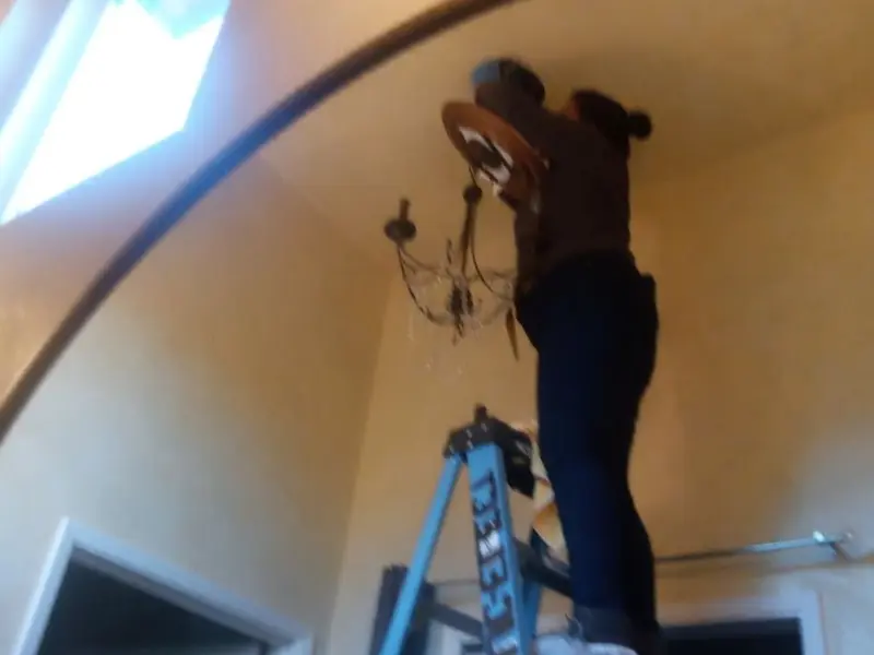 Electrician installing a chandelier in a Rothschild residence